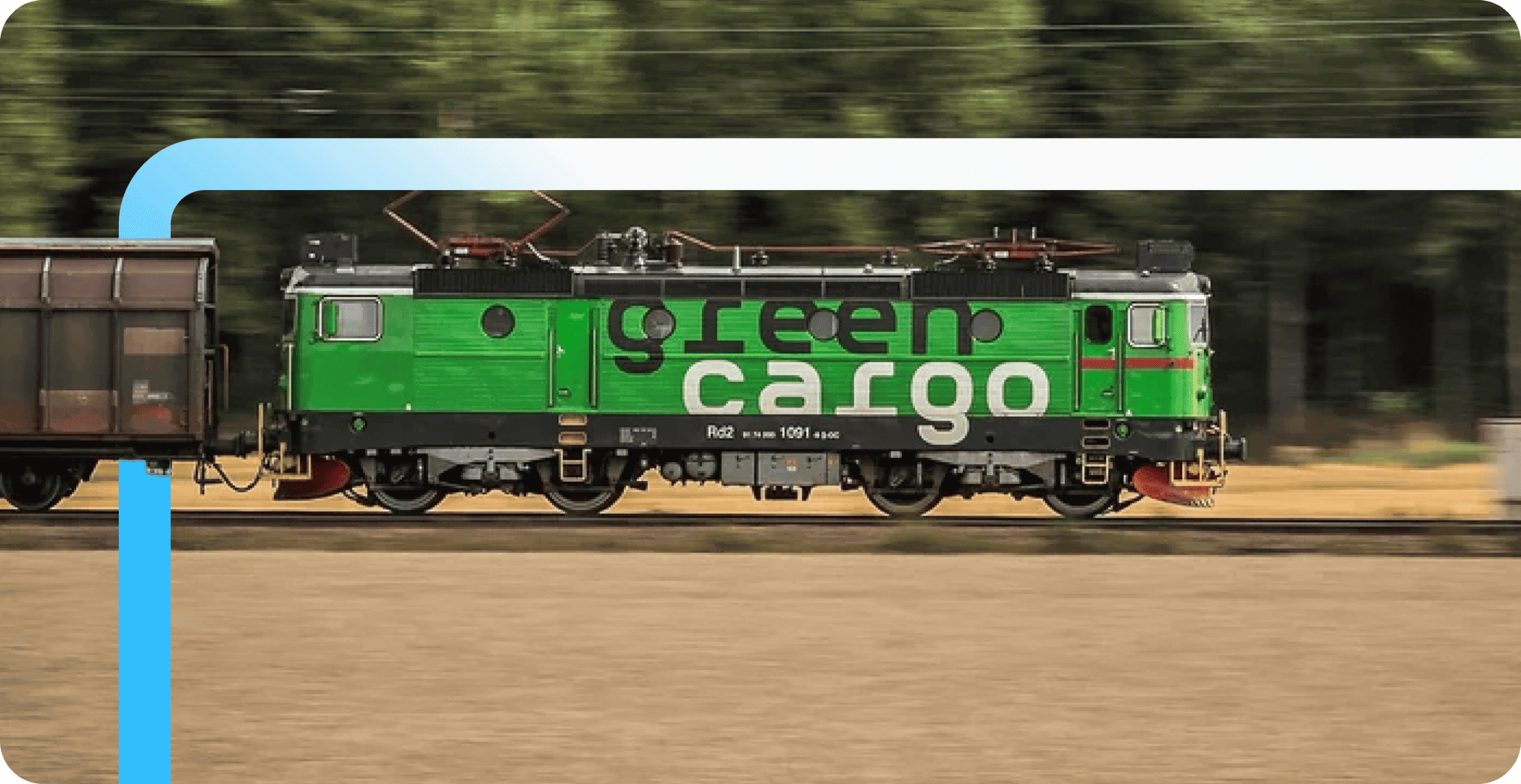 A green electric locomotive branded "green cargo" pulls a freight car along tracks with motion-blurred trees in the
