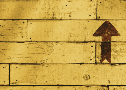 An arrow pointing up on a yellow wall.