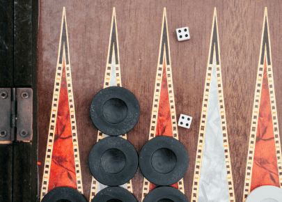 Image shows a board game with dice and discs