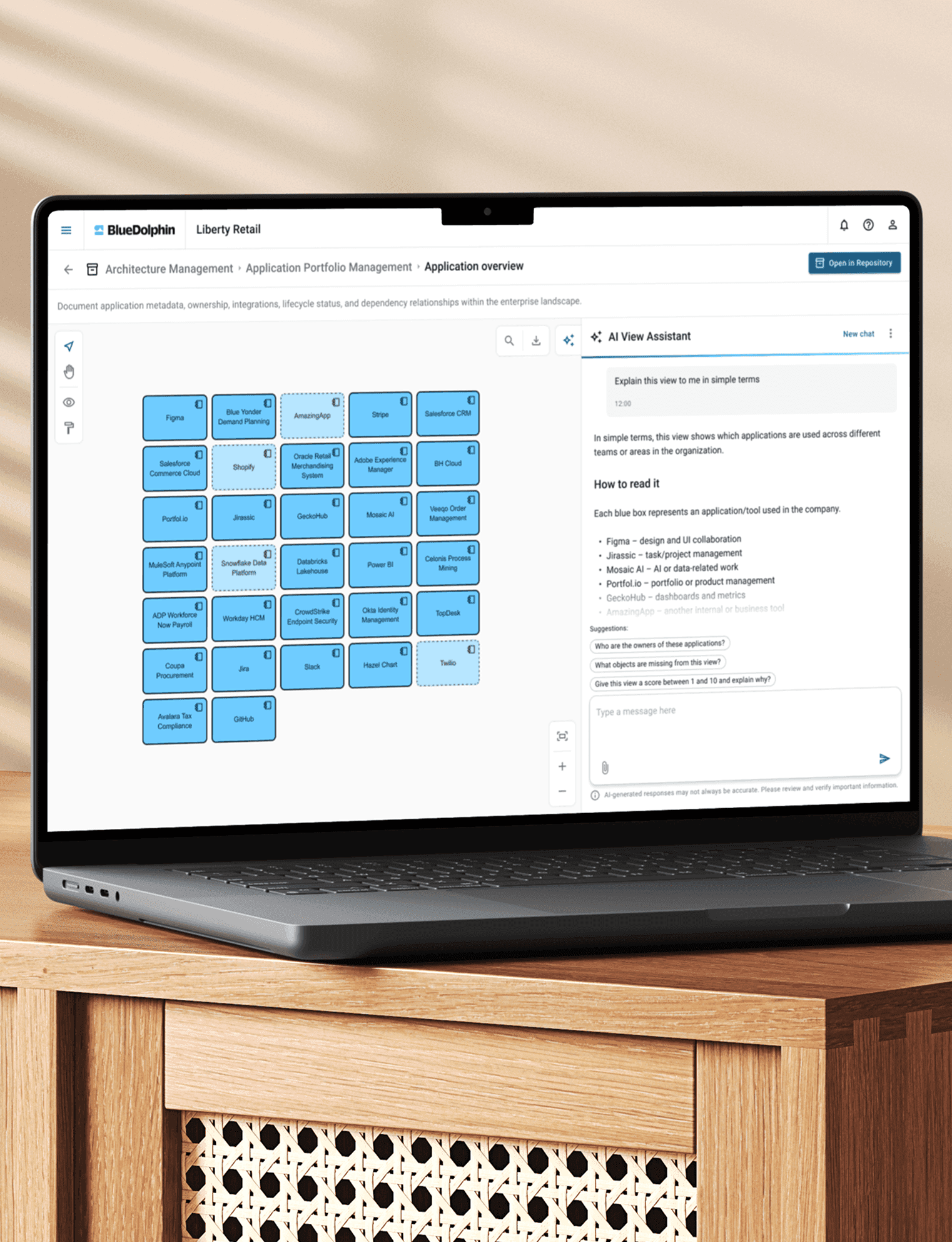 Laptop displaying BlueDolphin's Application Portfolio Management dashboard with app tiles and an AI View Assistant chat