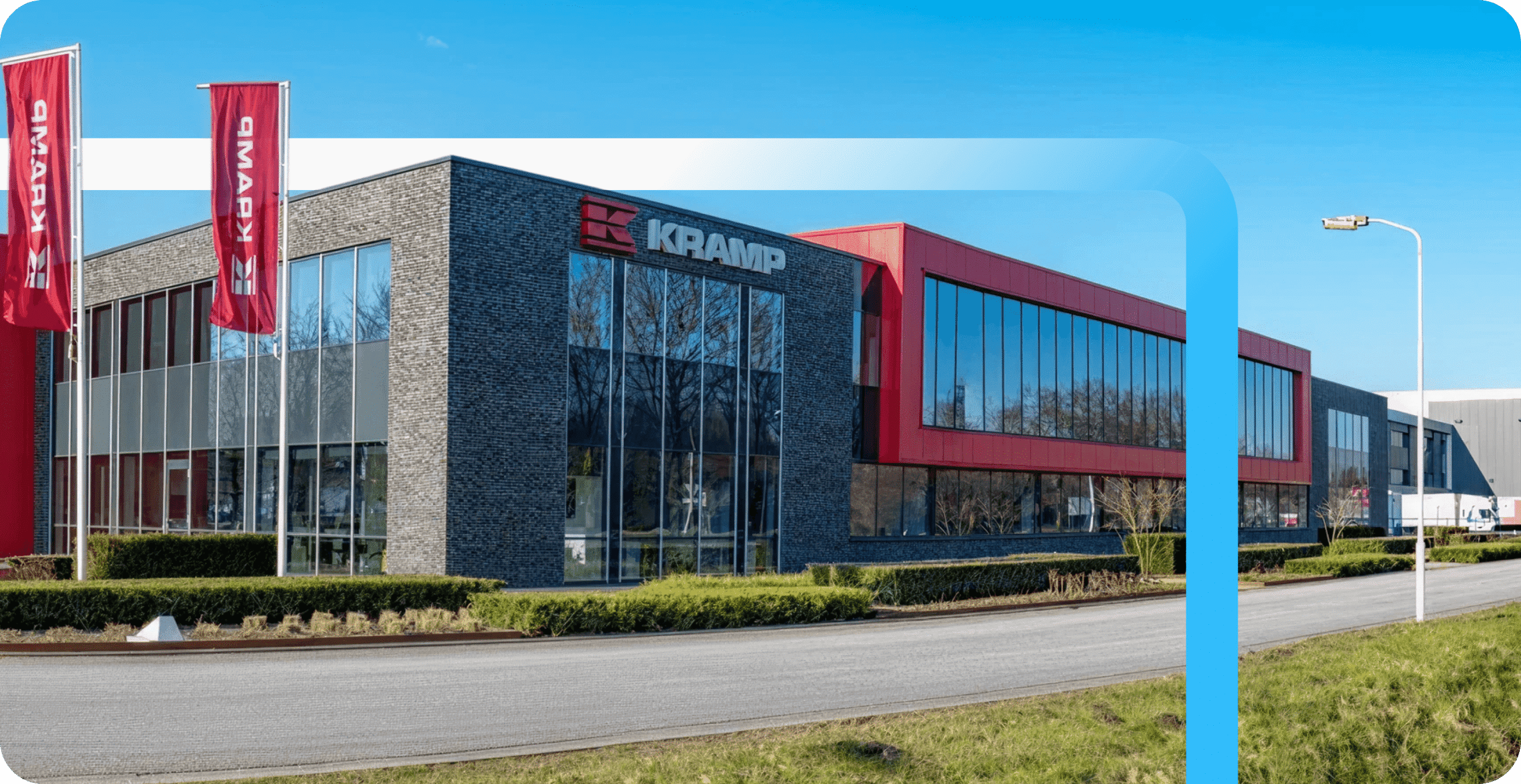 Kramp headquarters building with dark brick and red-accented facade, large glass windows, and red branded banners out front.
