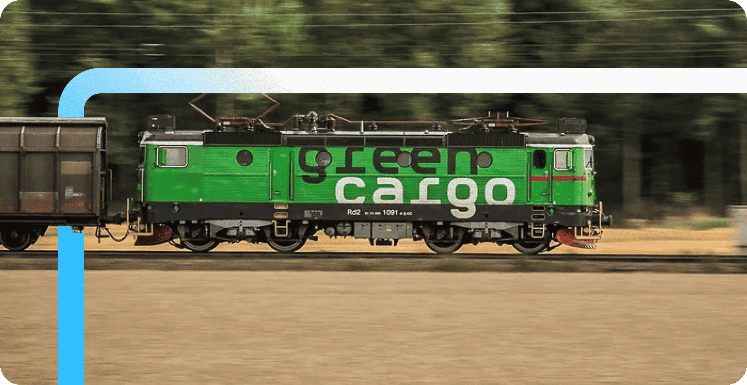 A green electric locomotive branded "green cargo" pulls a freight car along tracks with motion-blurred trees in the